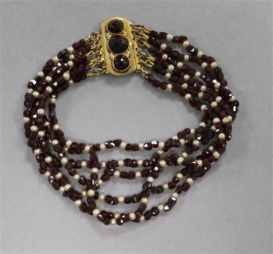 A garnet and seed pearl bracelet with yellow metal clasp.